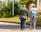 Ein älterer Mann und eine ältere Frau gehen einen Weg entlang.