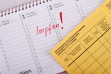 Geöffnetes Impbuch und Kalender mit Eintrag Impfen.