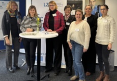 Mehrere Frauen stehen um einen Stehtisch herum.
