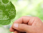 Eine Hand hält ein Blatt, darauf sind Zeichnungen von Bäumen, Menschen, Häusern.