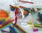 Auf einem Tisch liegen eine gefüllte Schultüte und Schreib- und Bastelutensilien verteilt.
