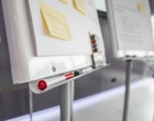 Zwei Moderationstafeln, an denen Notizzettel kleben und bunte Stifte liegen.