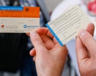 Zwei Hände halten die Vorder- und Rückseite eines Organspende-Ausweises in die Kamera.