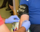 Medizinisches Personal nimmt einem Mann am Arm Blut ab.