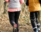 Zwei Personen joggen durch einen Wald.