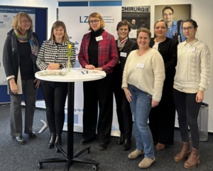 Mehrere Frauen stehen um einen Stehtisch herum.