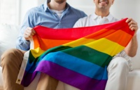Zwei Männer halten eine Regenbogenfahne