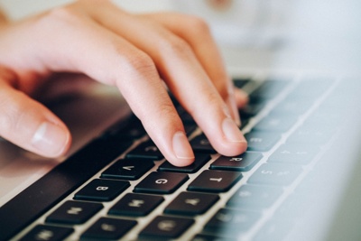 Finger tippen auf einer schwarzen Computertastatur