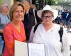 Ministerpräsidentin Malu Dreyer überreicht einer Frau eine Auszeichnung.