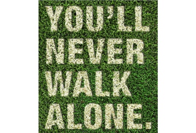 Ein Rasen, auf dem You'll never walk alone steht
