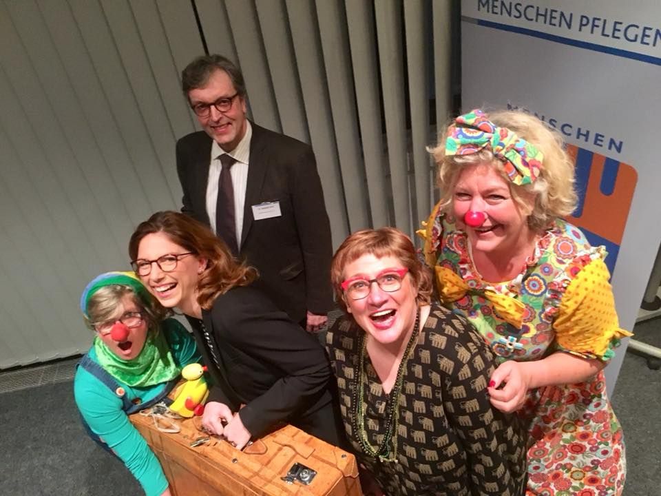 Fünf Personen schauen lachen in die Kamera.