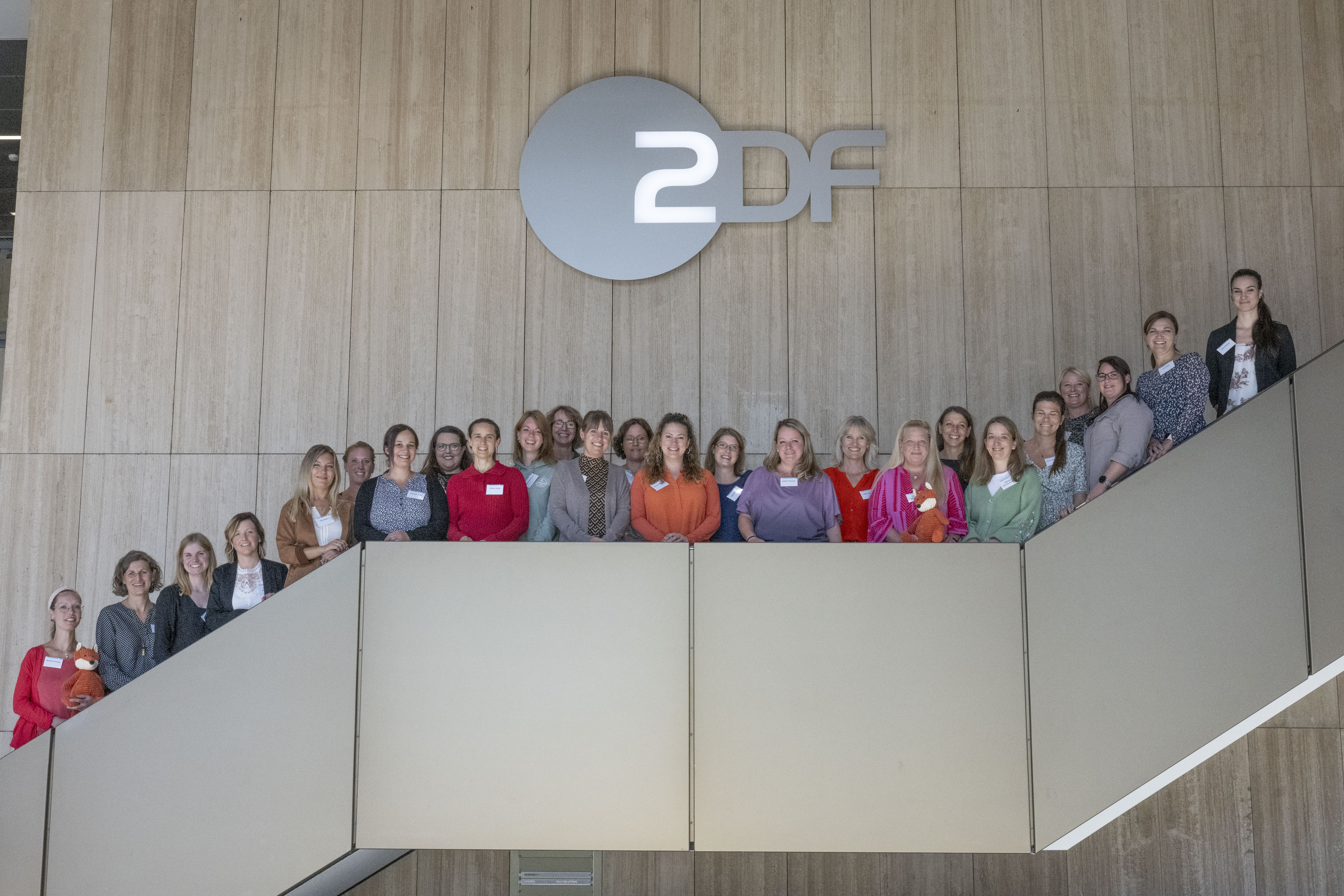 Gruppenbild mehrerer Personen, auf einer Treppe stehend.